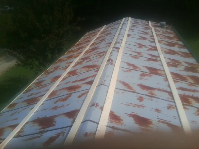 Rusted metal roof panels with new wood purlins before replacement — Storm Damage Roof Repair in Liberal by Roofing Brothers