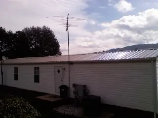 New metal roof on a single wide mobile home with a TV antenna in Liberal