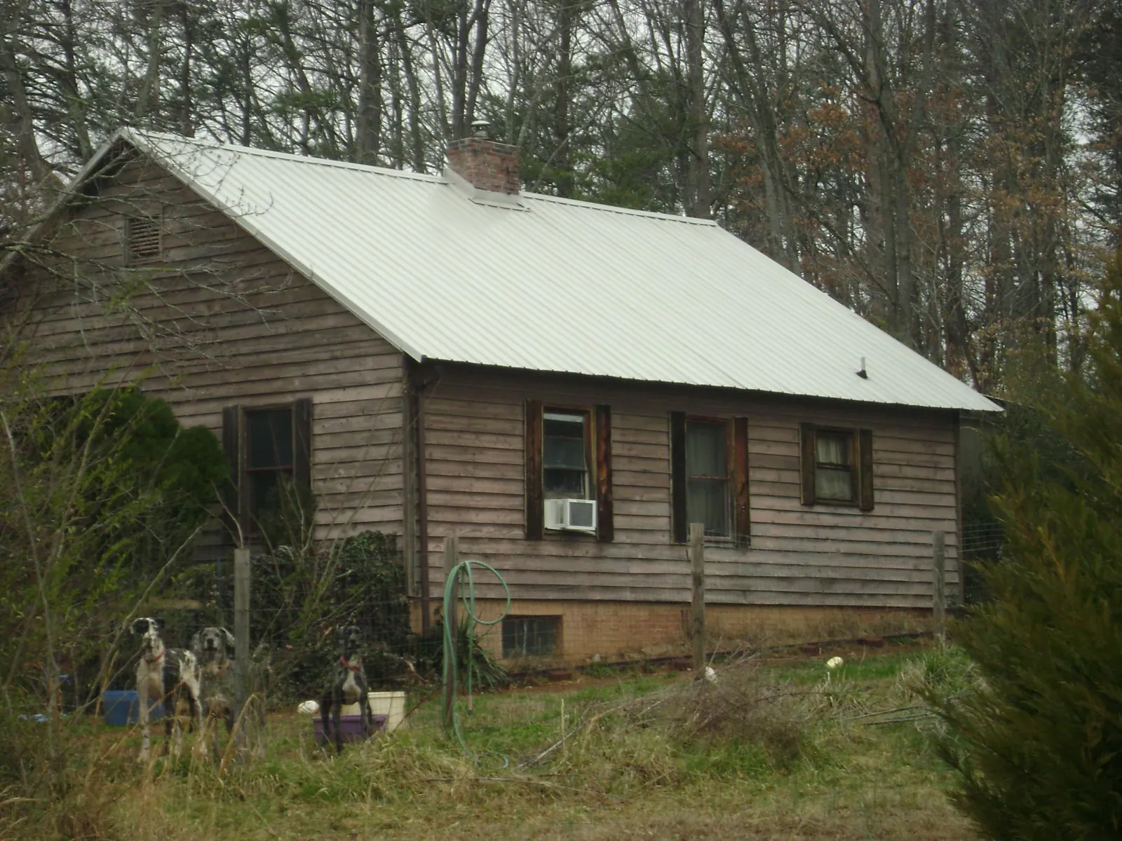 White metal roof on an old wood sided farmhouse, from a Metal Roof Installation job in Liberal